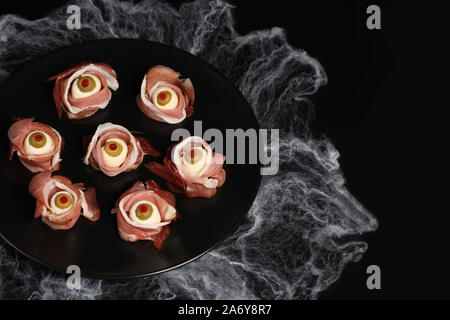 Halloween originali snack. Bulbi oculari cucinato da prosciutto con mozzarella di bufala, Olive farcite con peperone rosso Foto Stock