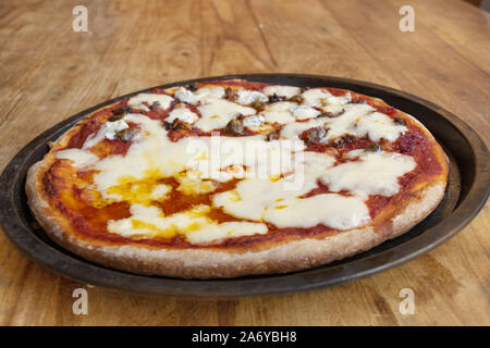 La cottura a vapore e acqua calda appena sfornato la pizza in un domestico teglia Foto Stock