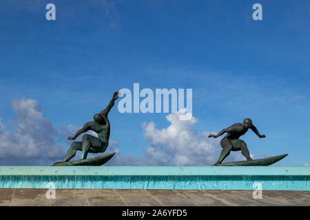 Coruna / Spagna - 23 Ottobre 2019: sculture in bronzo di surfisti in una fontana in Riazor Coruna Spagna Foto Stock