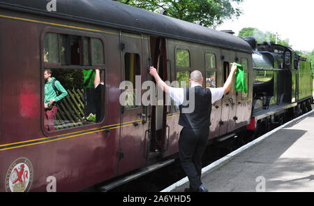 Segnalazione di guardia al treno a vapore, Haworth, ferrovie, Keighley e Worth Valley Railway Foto Stock