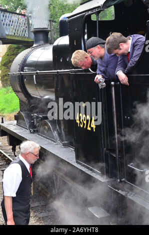 Treno a vapore e driver per i vigili del fuoco di parlare di guardia, KWVR, Keighley e Worth Valley Railway, Foto Stock