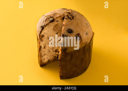 Natale Panettone al cioccolato torta isolato su sfondo giallo. Foto Stock