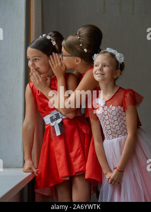 Vitebsk-Belarus. Europe-September orientale 19, 2019: tre ragazze di età inferiore ai quindici anni vestito di rosso brillante abiti da sera comunicare durante un b Foto Stock