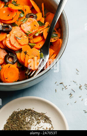 Marocchino tradizionale cotto Insalata di carote nord africana piatto vegano con il prezzemolo tritato e le olive su lastra grigia di close-up di spazio di copia Foto Stock