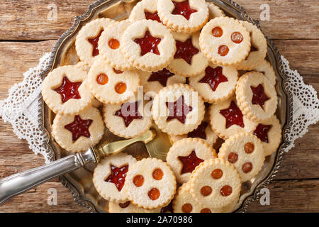 Gustoso sandwich di biscotti con la marmellata. Tradizionale pasticceria austriaca Linzer. Close-up su una piastra sul tavolo. Parte superiore orizzontale vista da sopra Foto Stock