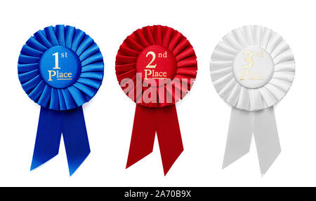 1st, 2 ° e 3 ° posto nastro pieghettato di rosette o badge in blu, rosso e bianco rispettivamente con testo centrale isolato in una fila su un fondo bianco Foto Stock