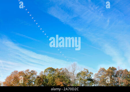 Foto composito Luna tracking attraverso il cielo blu verso il basso e verso la Autunno Autunno boschi, Foto Stock