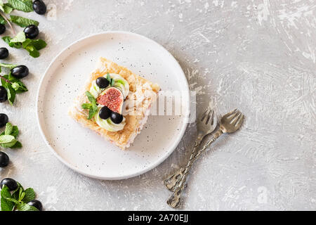 Pavlova su un biscotto con una delicata crema di cagliata, fichi e uva. Una nuova variante del classico dolce Australiano. Foto Stock