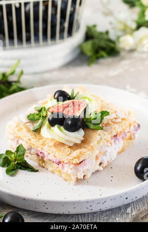 Pavlova su un biscotto con una delicata crema di cagliata, fichi e uva. Una nuova variante del classico dolce Australiano. Foto Stock