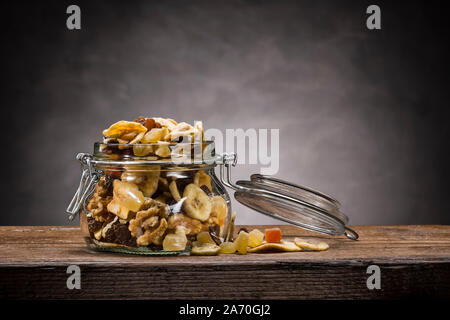 Frutta disidratata in aprire il vasetto di vetro sul tavolo di legno Foto Stock