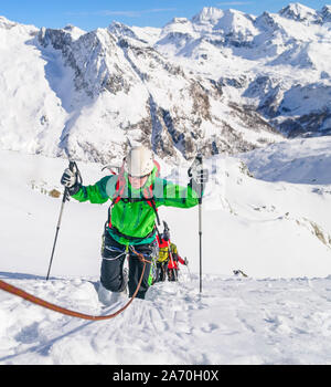 Fune ascendente del team alla cima della montagna in alto la regione alpina in inverno Foto Stock