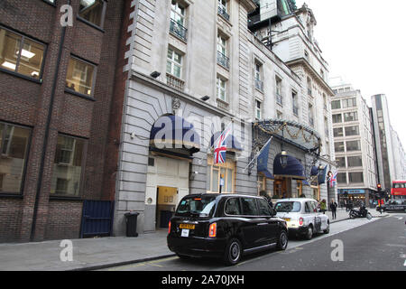 Ingresso al Ritz Hotel guardando a nord su Arlington Street, Mayfair, Londra, taxi nero parcheggiato fuori dall'hotel Ritz Foto Stock