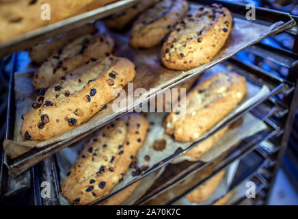 Dresden, Germania. Xviii oct, 2019. Appena sfornato il Natale lo Stollen giacciono su carrelli di trasporto in Dresden casa di cottura alla finestra aperta e raffreddare. Il Dresden Christstollen è fatto a mano da circa 130 panetterie e pasticcerie nei dintorni di Dresda secondo ricette tradizionali. I prigionieri solo che soddisfano i requisiti dell'Stollen associazione di protezione possono recare il prigioniero di tenuta come un segno di autenticità. Credito: Jens Büttner/dpa-Zentralbild/ZB/dpa/Alamy Live News Foto Stock