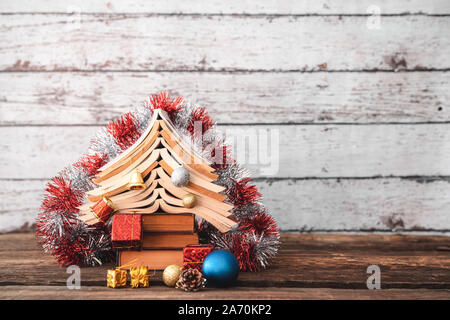 Decorazione di natale con ornamenti e albero di Natale da libri. Foto Stock