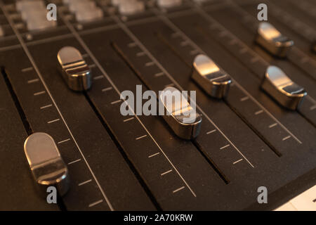 Una chiusura di argento-cursori colorati su una console di mixaggio in uno studio musicale nessuno nell'immagine Foto Stock