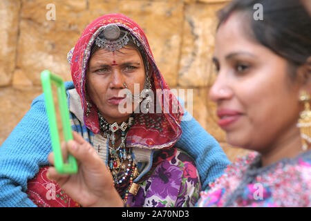 Un kalbelia rajasthani donna vedere un giovane turista adolescente a Jaisalmer fort nello stato indiano del Rajasthan. Foto/Sumit Saraswat Foto Stock