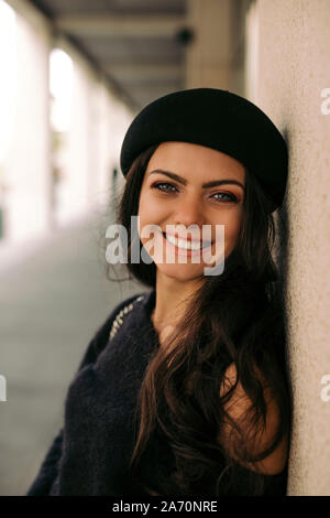 Bella bruna donna vestita in stile retrò godendo la vita estiva della vecchia città europea. Passeggiando per la città. Foto Stock