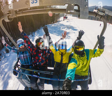 Gli amici di ski lift tenendo selfie Foto Stock