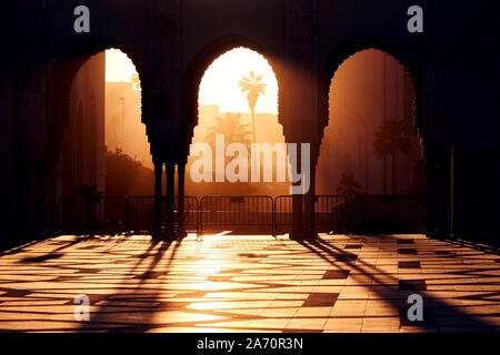 Grande Moschea di Hassan 2 al tramonto a Casablanca, in Marocco. Belle arcate della moschea araba al tramonto, i raggi di luce solare Foto Stock