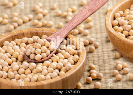 Chiudere uo di una ciotola di legno pieno di deliziosi fagioli di soia Foto Stock