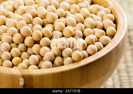 Chiudere uo di una ciotola di legno pieno di deliziosi fagioli di soia Foto Stock