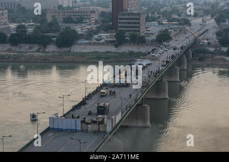 Baghdad in Iraq. 29 ott 2019. Le forze di sicurezza irachene blocco Al ponte Jumhuriya durante gli scontri con anti-governo manifestanti vicino a Piazza Liberazione. Le autorità irachene ha imposto un coprifuoco notturno di lunedì a Baghdad e in altre province per sedare proteste contro il governo che sono in corso sin dal venerdì, chiedendo al governo di rassegnare le dimissioni, lo scioglimento del parlamento ed elezioni anticipate. Credito: Ameer Al Mohammedaw/dpa/Alamy Live News Foto Stock