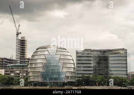 Vista orizzontale di forma sferica e futuristico municipio edificio sul Tamigi in un giorno nuvoloso. Situato a Southwark e progettato da Norman Foster Foto Stock