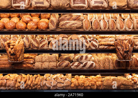 Deliziosa pagnotte di pane in un tedesco baker shop. Diversi tipi di pani su ripiani di panetteria. Foto Stock