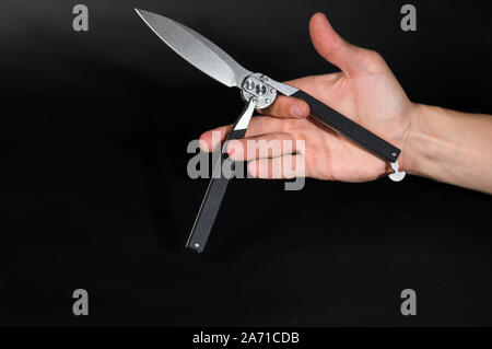 Coltello Balisong nel palmo della tua mano. Trucco con un coltello. Foto Stock