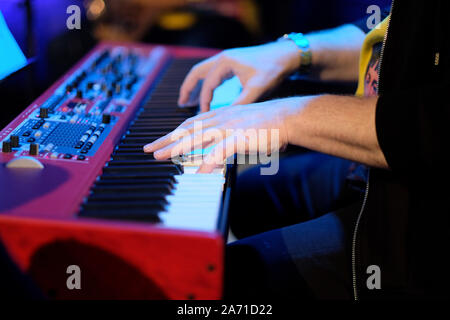 Un musicista in un pianoforte elettrico suona musica dal vivo in un concerto in un'orchestra Foto Stock