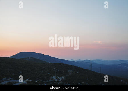 Vista spettacolare dalla cima delle alte colline stratificata con nebbia dopo il tramonto Foto Stock