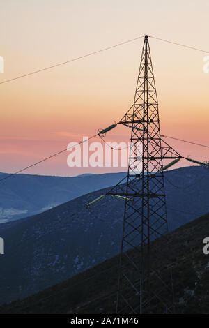 Bella vista dalla cima della montagna durante il tramonto con fili di elettricità nella parte anteriore che simboleggiano la presenza umana nella natura Foto Stock