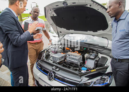 (191029) -- KIGALI, Ottobre 29, 2019 (Xinhua) -- Un ingegnere della Volkswagen (VW) spiega il sistema di VW auto elettrica e-Golf a Kigali, Ruanda, ad Ottobre 29, 2019. Casa automobilistica tedesca Volkswagen martedì ha lanciato un progetto pilota della sua auto elettrica e-Golf in partnership con tecnologia tedesca Siemens gigante a Kigali, che rende il Ruanda il primo paese dell Africa subsahariana dove VW introduce un auto elettrica. (Foto di Cirillo Ndegeya/Xinhua) Foto Stock