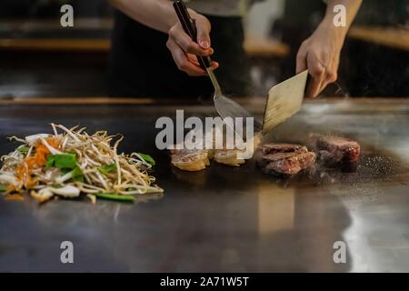 Teppan mostrano in un ristorante Giapponese, cucina direttamente di fronte al cliente, pesce, riso, carne e verdure Foto Stock