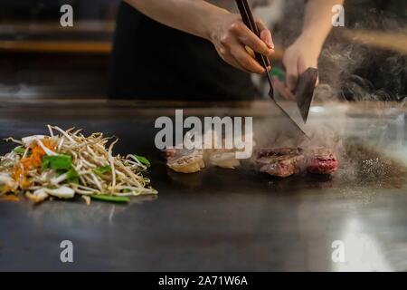 Teppan mostrano in un ristorante Giapponese, cucina direttamente di fronte al cliente, pesce, riso, carne e verdure Foto Stock