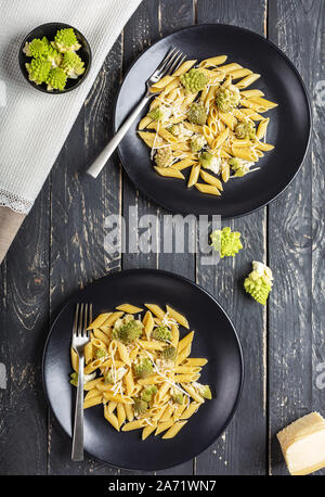 Penne pasta con cavolo Broccolo romanesco darck su sfondo di legno Foto Stock