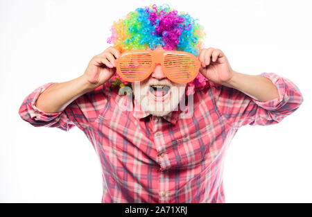 Uomo Barbuto senior persona allegra usura colorata parrucca e occhiali da sole. Anziani clown. Avendo divertimento. Stile di vita divertente. Divertimento e intrattenimento. Fumetto nonno concetto. Bello scherzo. Il nonno sempre divertente. Foto Stock