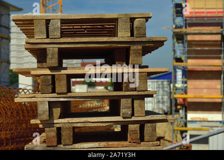 I pallet in legno vengono impilate su un sito in costruzione Foto Stock