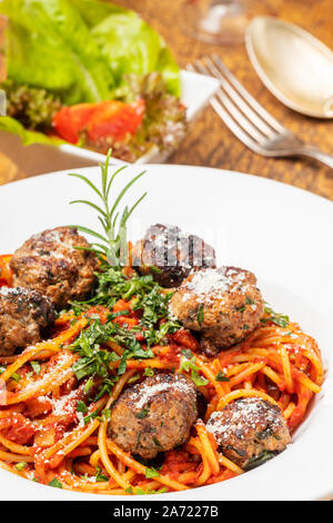 Spaghetti con polpettine di carne in legno scuro Foto Stock