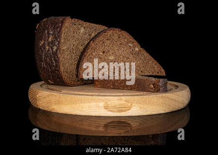 Gruppo di una metà due fette di freschi di forno pane scuro sulla piastra di bambù isolato sul vetro nero Foto Stock