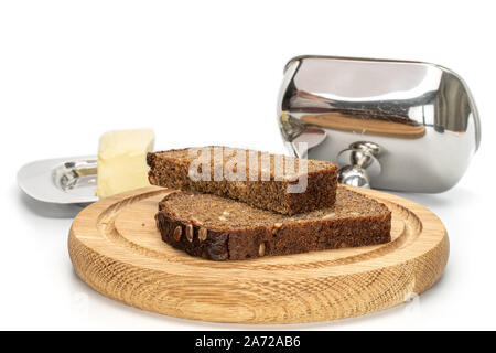 Gruppo di due fette di freschi di forno pane scuro sulla piastra di bambù con burro piatto isolato su sfondo bianco Foto Stock