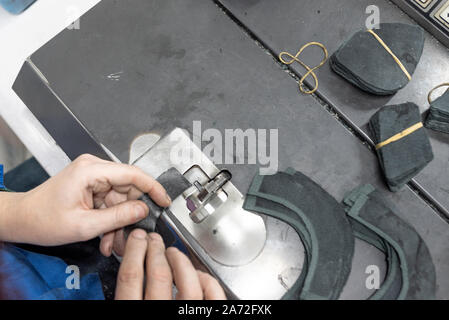 Abbassando i bordi delle parti. Produzione di calzature. Foto Stock