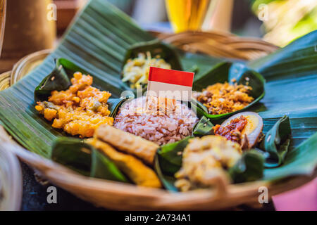 Nasi lemak, Nasi campur, Indonesiana riso Balinesi con delle crocchette di patate, sate DISPOSITIVO HIRON JARAC JUPITER BASSA LILIT, tofu fritto, piccante uova sode, e arachide Foto Stock