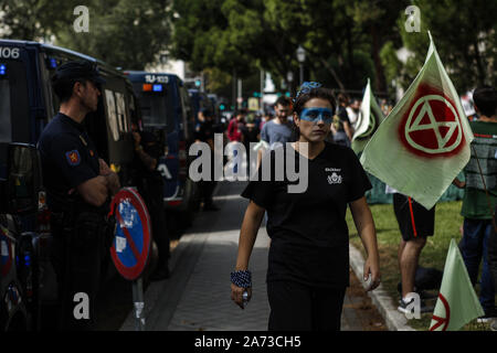 Madrid, Spagna. Il 7 ottobre, 2019. Clima passeggiate attivista passato un funzionario di polizia durante la dimostrazione.centinaia di attivisti del clima dalla ribellione di estinzione movimento di protesta, gli attivisti hanno paralizzato la strada principale della città e poi si accamparono di fronte Spagna Ministero dell Ambiente e cambiamenti climatici per cinque giorni. Credito: Guillermo Santos SOPA/images/ZUMA filo/Alamy Live News Foto Stock