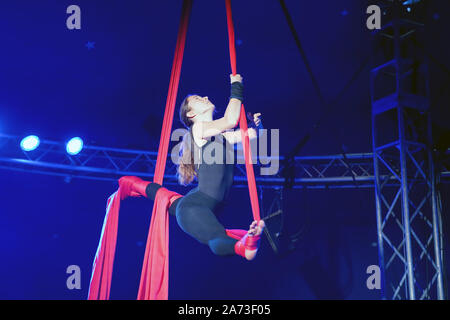 Giovani acrobat mostra le sue abilità sulla verticale della fune panno nel circus Giovanni a Bamberg in Germania --- Junge Akrobatin zeigt ihr Können am Vertikaltuch im Zirkus Giovanni di Bamberg, Deutschland Foto Stock