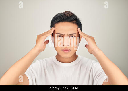 Persone, stress, tensione e concetto di emicrania. Sconvolto infelice giovane spremitura di testa con le mani, che soffrono di mal di testa Foto Stock