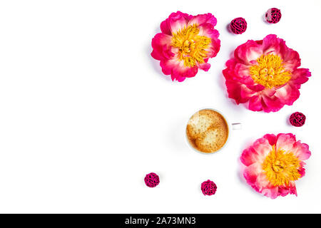 White tazza di caffè e bellissime le peonie sul bianco isolato desk. Appartamento laico, vista dall'alto, copia dello spazio. Foto Stock