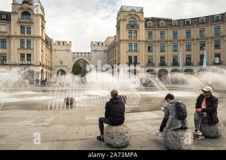 Karlsplatz (Stachus), Monaco di Baviera, in Germania, un luogo vivace con una fontana e gli edifici storici, come il Karlstor porta gotica. Foto Stock