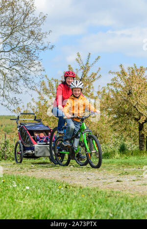 Godendo di primavera la natura durante una gita in bicicletta con la famiglia Foto Stock