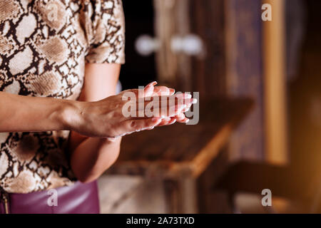Close up foto di donna con le mani in mano l'applicazione di crema mani. Cura della pelle, la cura del corpo, prodotti di bellezza, spa, cura dei capelli concetto. Foto Stock